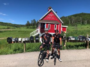 Tad Smith and Mark Nuccio in custom cycling gear in front of the old school house in Steamboat Springs, CO.