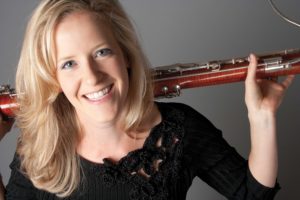 Woman poses with bassoon.