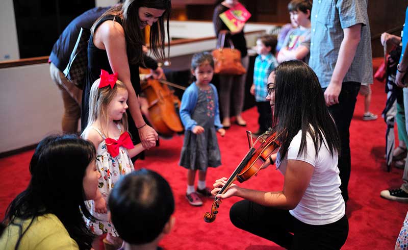 Children admire musicians' instruments in the Jones Hall lobby.