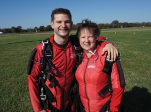 Mother and son pose after skydiving.