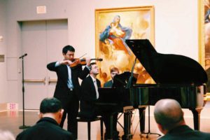 Violinist and pianist perform together.