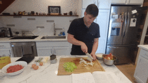 Man chopping onions in a kitchen.