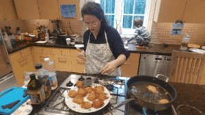 Woman placing potato latkes on a plate.